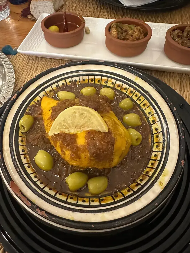 Tajine et assortiment de mezze dans de petits plats en terre cuite.