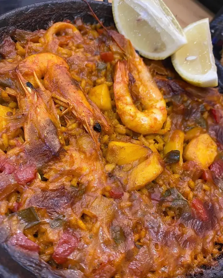 Riz aux fruits de mer avec gambas et calmars, quartiers de citron.